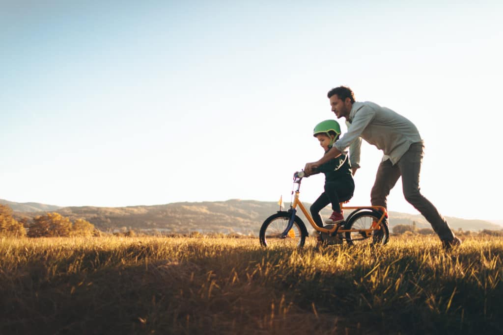 Father teaching his son how to ride his bike.