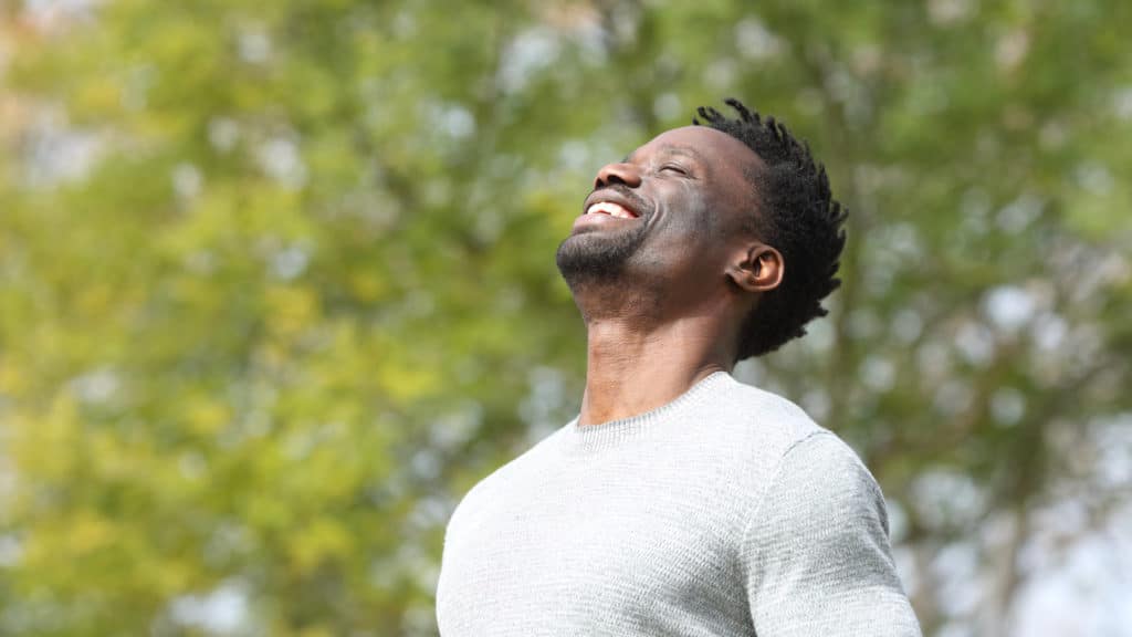 Man smiling in a field after psychiatric counseling