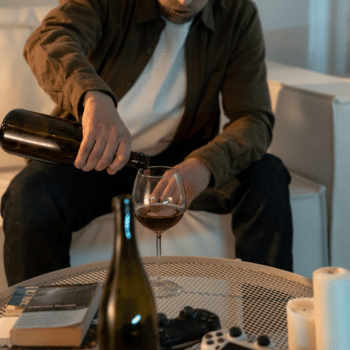 man pouring alcohol into a glass because he is addicted
