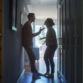 couple arguing in a dark hallway because they are having relationship issues